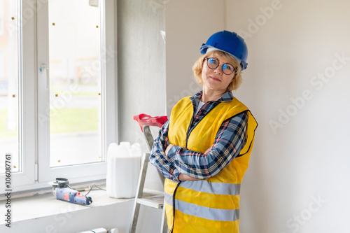 Woman Builder in the room of the house making repairs.