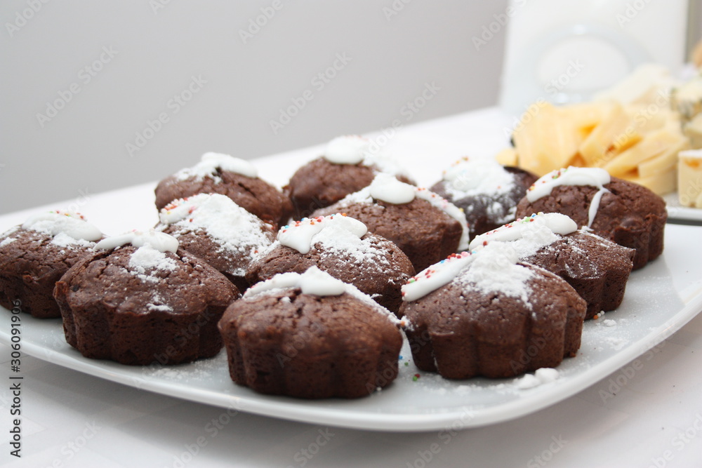 Chocolate muffins with icing sugar on a white plate Chocolate muffins with icing sugar on a white plate