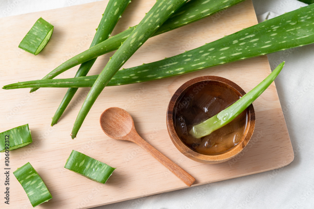 Cut aloe vera stem and gel in wooden bowl on wooden background Cut aloe vera stem and gel in wooden bowl on wooden background