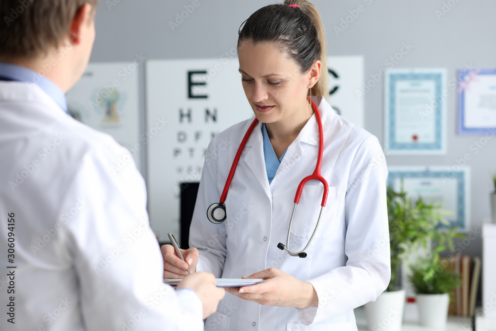 Female doctor hold silver pen in hand against Female doctor hold silver pen in hand against