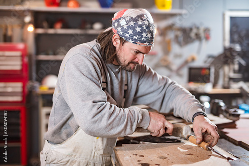 Carpenter working on a old wood in a retro vintage workshop.