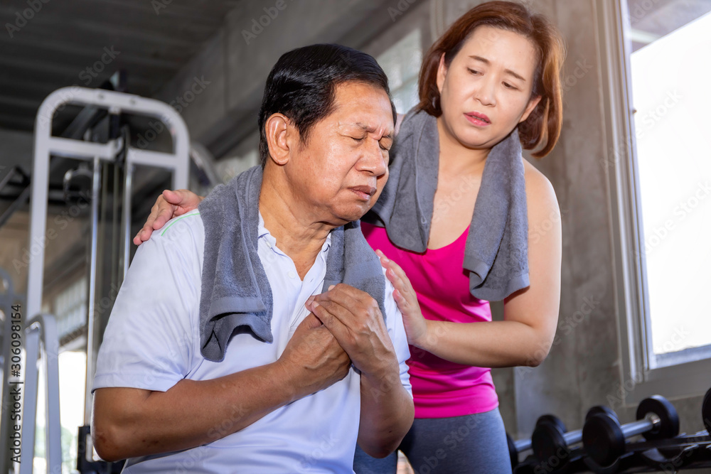Senior man Asian heart attack during training with wife at fitness gym.