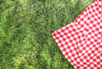 Picnic cloth on green grass background empty space.