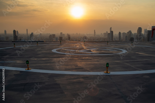 Selective focus of the Heli Copter parking lot on the deck at sunset in the capital of Thailand. Space for helicopter landing on high-rise buildings in Bangkok, Thailand.