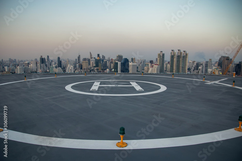 Selective focus of the Heli Copter parking lot on the deck at sunset in the capital of Thailand. Space for helicopter landing on high-rise buildings in Bangkok, Thailand.
