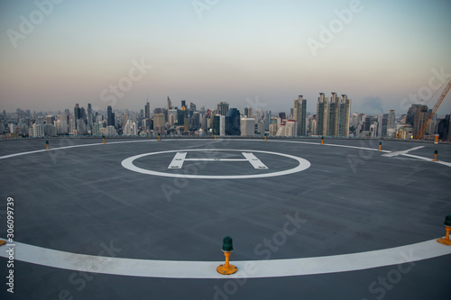 Selective focus of the Heli Copter parking lot on the deck at sunset in the capital of Thailand. Space for helicopter landing on high-rise buildings in Bangkok, Thailand.