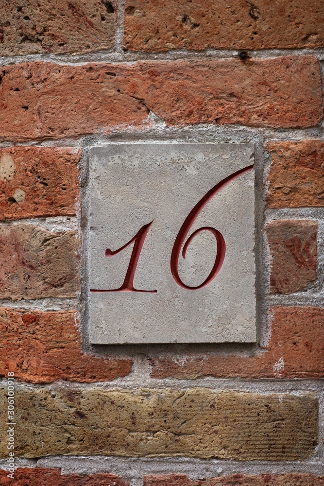 number 16 carving on brick wall number 16 carving on brick wall
