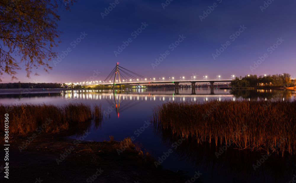 Night view of the Pivnichnyi Bridge - Northern Bridge (ex Moskovsky bridge) on the Dnieper river in Kiev, Ukraine, at evening during the blue hour