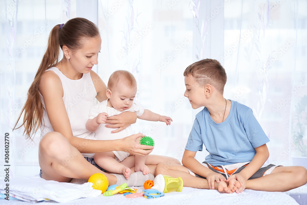 mom and son are playing with a newborn baby mom and son are playing with a newborn baby