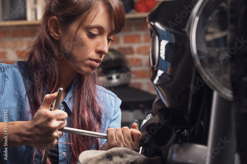 Female mechanic working on a vintage motorbike