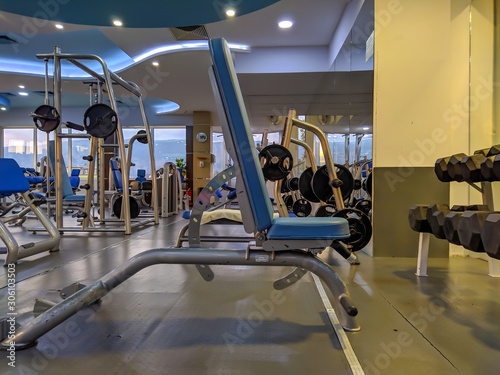 Bench for weight lifting and bodybuilding in an indoor modern empty gym with a lot of equipment for healthy lifestyle and recreation