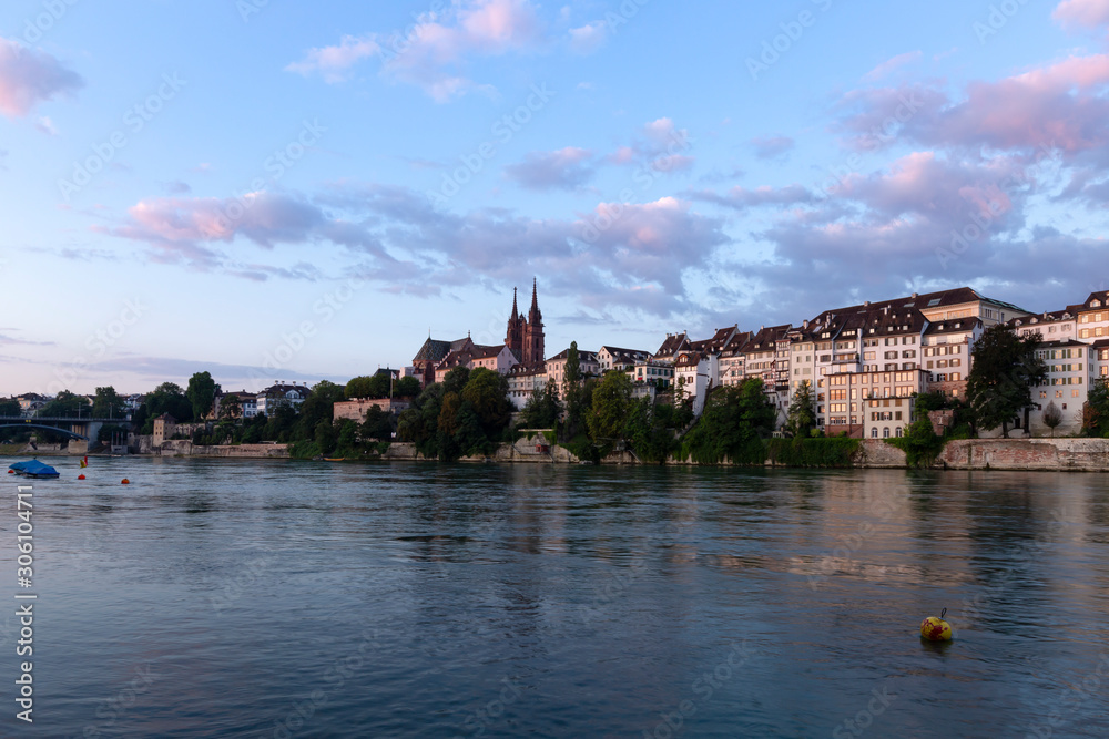 Switzerland, Basel, Oberer Rheinweg, 3rd of August 2019. Panoramic view across the rhine river at the skyline of the old town of Basel during sunrise.