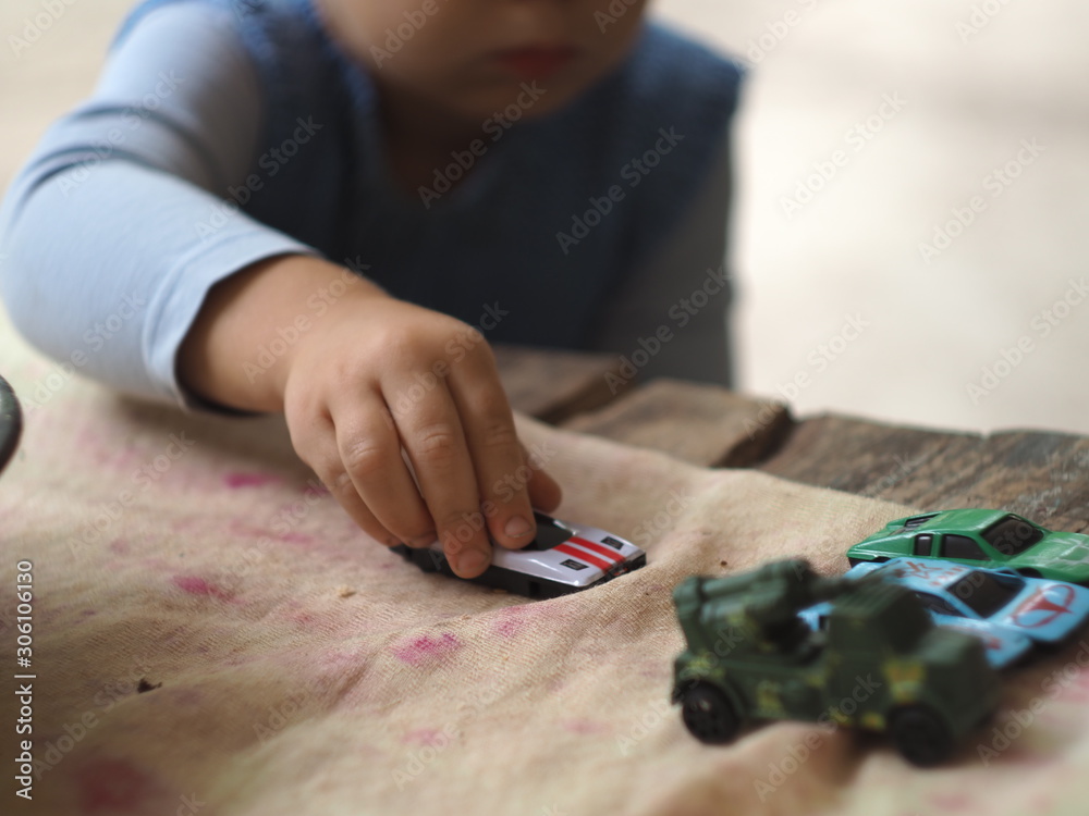 Baby toy in baby's hand. Childrens game with toy car closeup on the nature. Baby toy in baby's hand. Childrens game with toy car closeup on the nature.