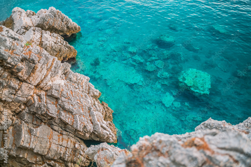 Beautiful sea coast of the Adriatic sea. Azure water and brown rocks.