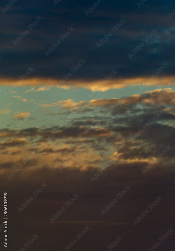 Fototapeta premium Fantastic clouds at sunrise, vertical panorama