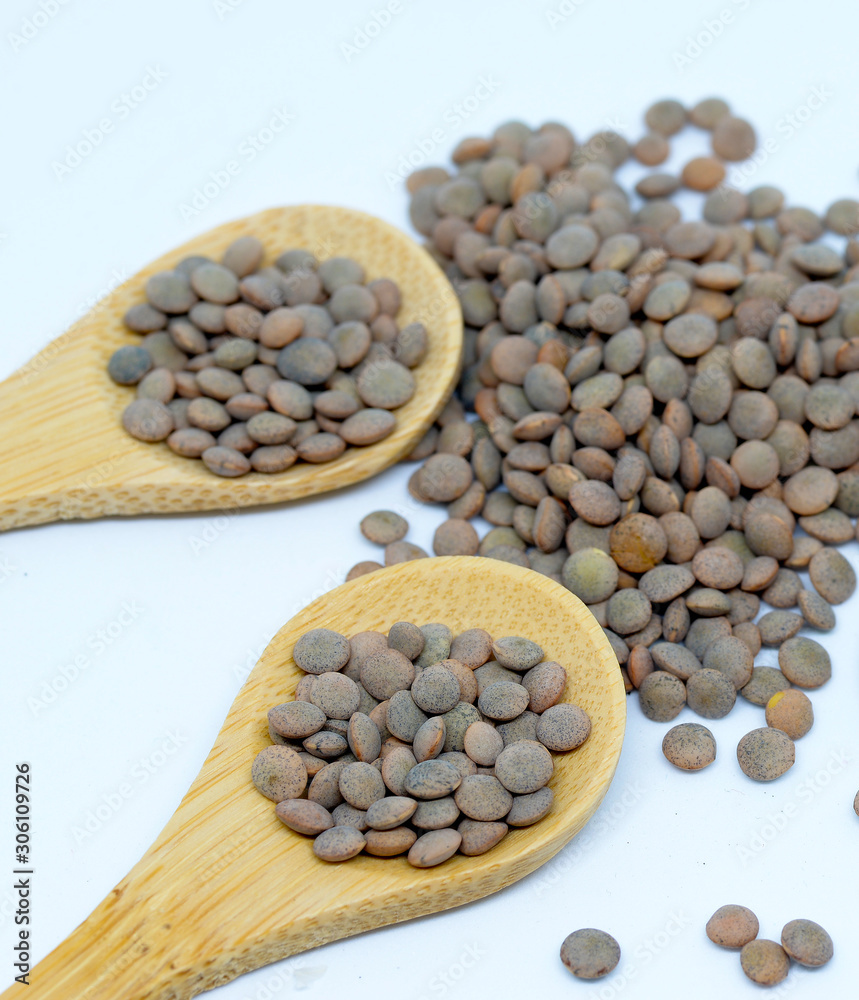 Lentils with white background and wooden spoon Lentils with white background and wooden spoon
