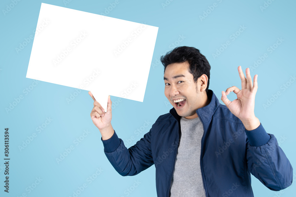 Delivery man is holding white black speech bubble on blue background. Delivery man is holding white black speech bubble on blue background.