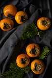 orange persimmon on a dark background. Beautiful layout. Bright fruit
