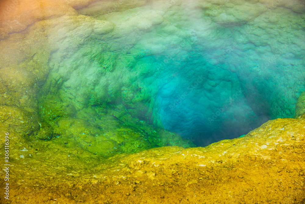 Colorful geyser basin with boiling water from geothermal heat.