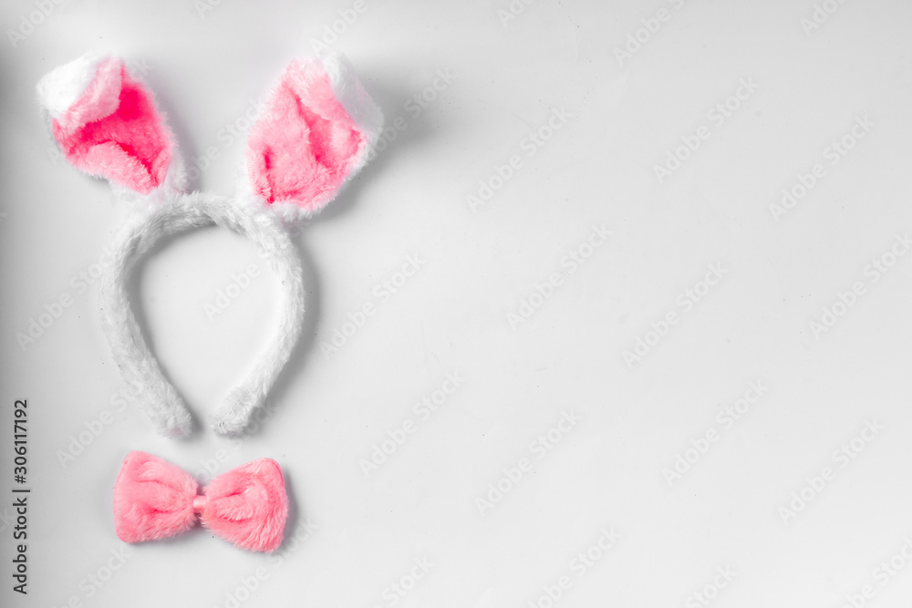 Top view of cute bunny ears with a small pink bow on wooden background. Top view of cute bunny ears with a small pink bow on wooden background.