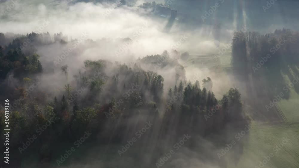 Aerial photograph in the Swiss Midland on an autumn morning with fog shining through the sun's rays near Sursee, Lucerne Aerial photograph in the Swiss Midland on an autumn morning with fog shining through the sun's rays near Sursee, Lucerne