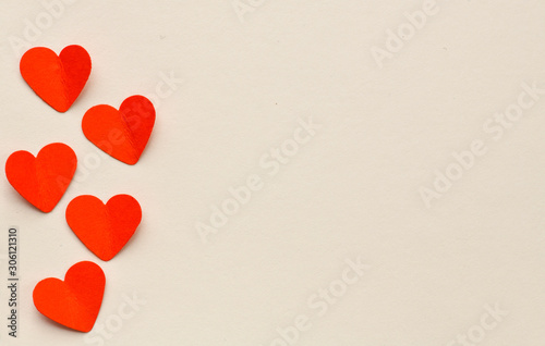 Red paper hearts on a white paper background. Perfect background for Valentine's Day or a postcard. High resolution photo.