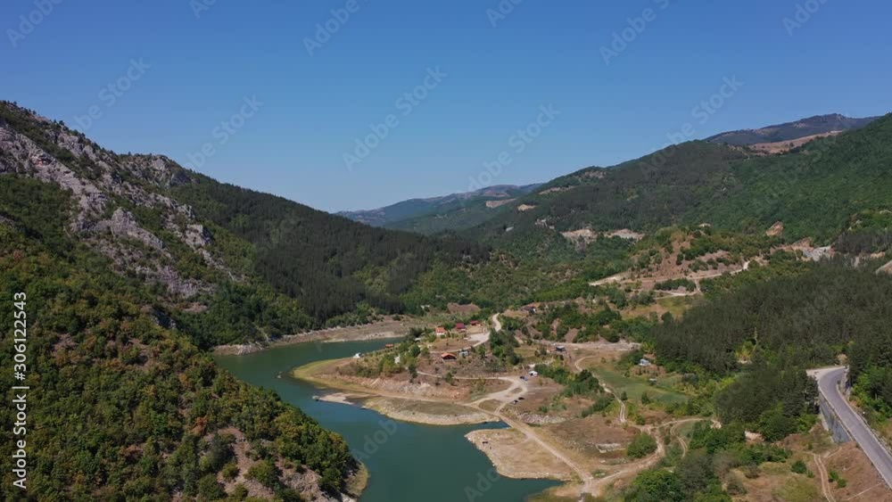 Flying up between the hills in the mountains with river and road in sight Flying up between the hills in the mountains with river and road in sight