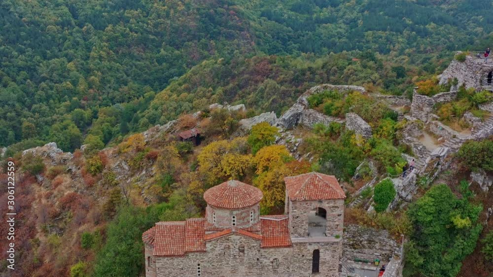 Flying down revealing the ancient Asen fortress in Rhodope mountains during a colorful
