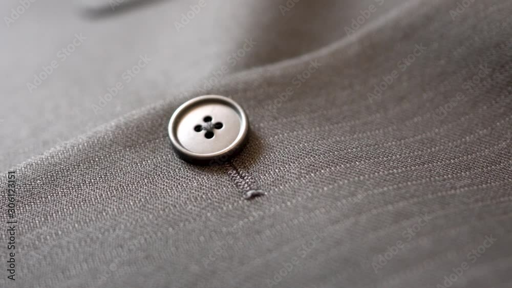 Close up part of men's suit fabric design details, dark grey straight stripe jacket, focus on button Close up part of men's suit fabric design details, dark grey straight stripe jacket, focus on button