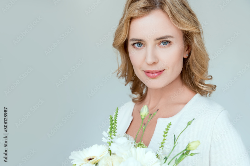 attractive woman with bouquet looking at camera isolated on grey attractive woman with bouquet looking at camera isolated on grey