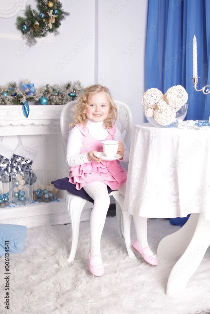 girl sits at a table and drinks from a large porcelain cup