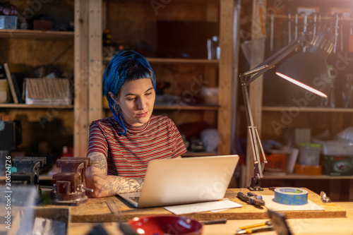 Young woman using laptop in her workshop