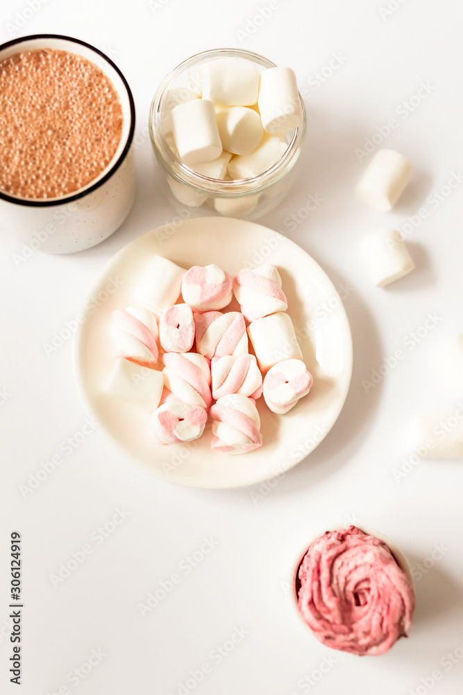 Cup of hot flavored cocoa with marshmallows on a white background. Christmas composition with cocoa. Cozy home mood. Cup of hot flavored cocoa with marshmallows on a white background. Christmas composition with cocoa. Cozy home mood.