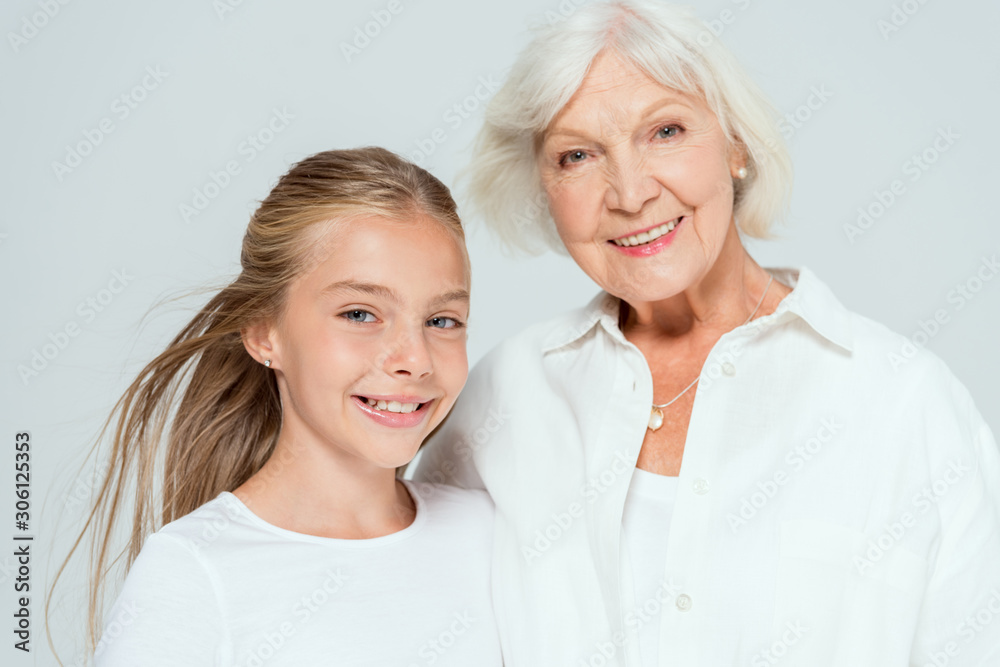 smiling granddaughter and grandmother looking at camera isolated on grey smiling granddaughter and grandmother looking at camera isolated on grey