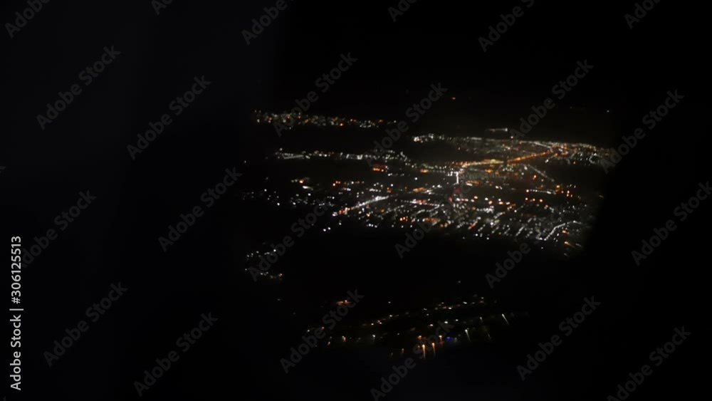 View of city lights through an airplane porthole View of city lights through an airplane porthole