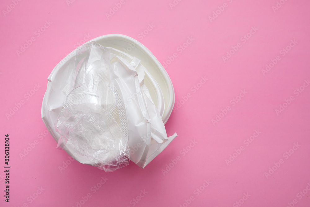plastic dish and plastic cup on  pink paper background