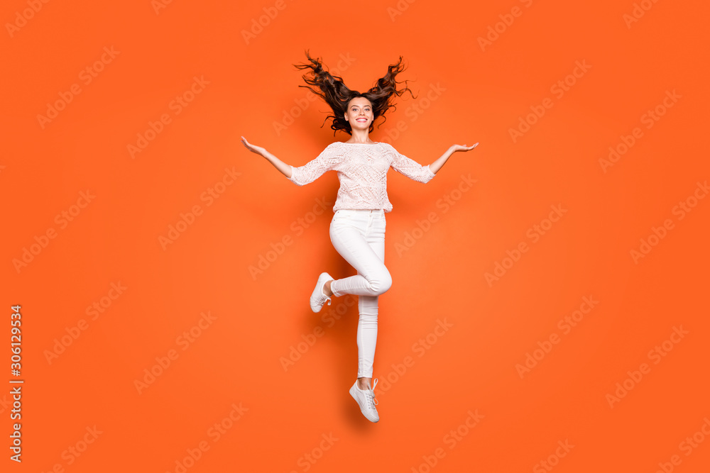 Full size photo of cheerful positive girl dream dreamy hold hand show her wavy luxury haircut jump wear lace knitted outfit sneakers isolated over orange color background