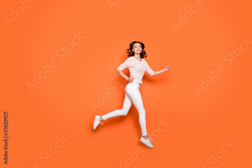 Full size profile side photo of positive cheerful girl jump run after sales discounts feel sport sporty wear good looking outfit isolated over orange color