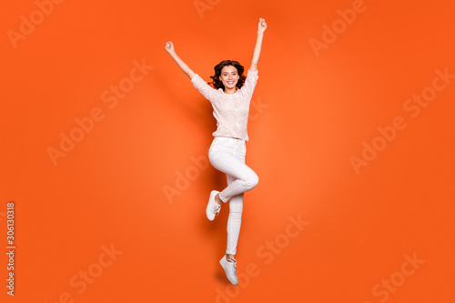 Full length photo of ecstatic girl jump have fun win spring time lottery raise fists wear casual style clothing isolated over bright color background
