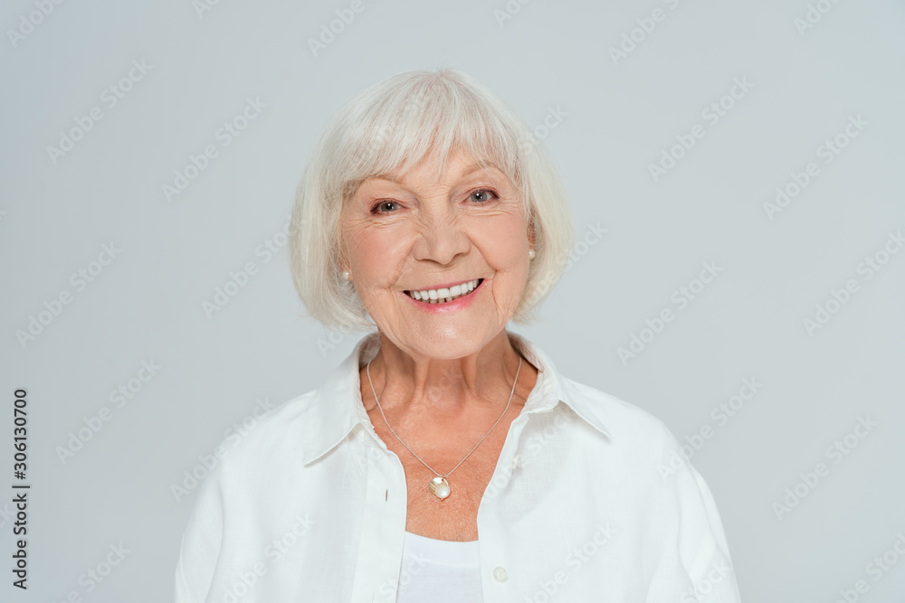 attractive and smiling woman looking at camera isolated on grey attractive and smiling woman looking at camera isolated on grey