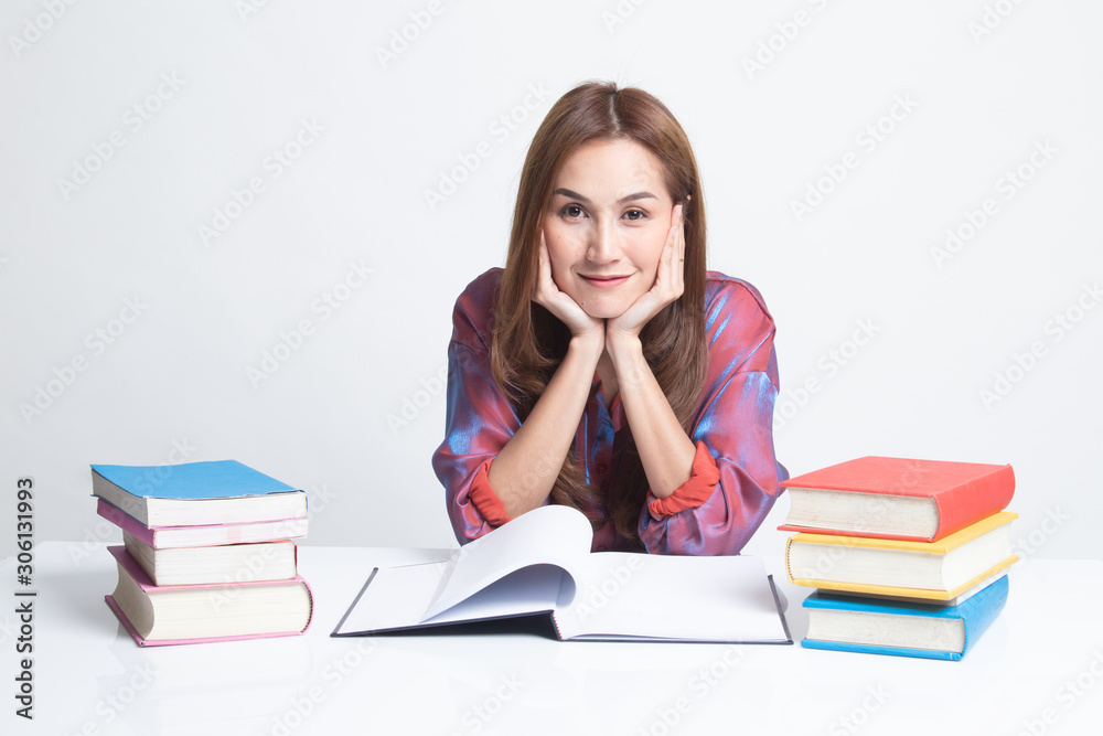 Young Asian woman read a book with books on table. Young Asian woman read a book with books on table.