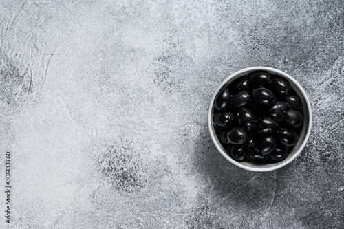 Seedless black olives. Gray background. Top view. Space for text