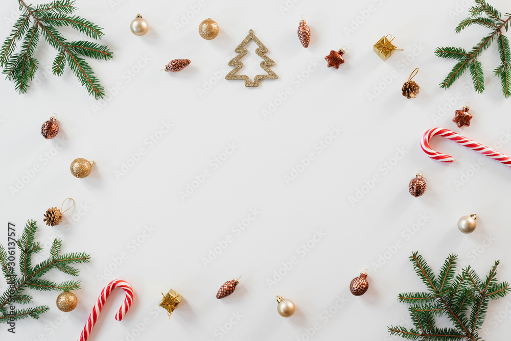 Christmas or new year frame compositions. Christmas decorations and fir branches on white background with copy space for text. the concept for holiday cards or invitations. the view from the top Christmas or new year frame compositions. Christmas decorations and fir branches on white background with copy space for text. the concept for holiday cards or invitations. the view from the top