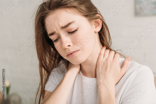 upset girl touching neck while suffering from pain