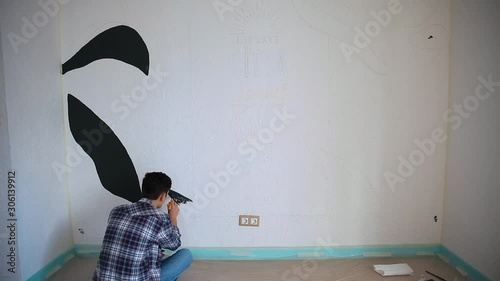 Young artist painting the wall carefully with a brush
