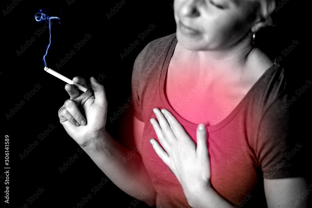 Obraz premium Woman smokes cigarette and has problem with lungs or heart attack.
