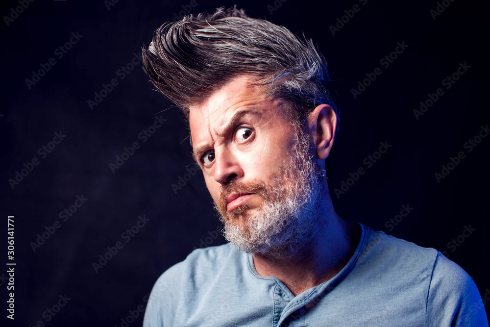 Bearded man with surprised face in front of black background