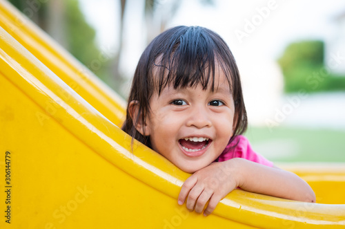 Cute asian little girl is playing in the playground with fully happiness moment, concept of outdoor learning activity for kid.