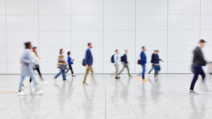 Crowd of business people walks by gear on trade fair