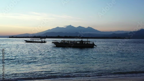 A Beautiful Morning In Phi  Phi Island With A Cool Breeze Of The Ocean, Floating Vessels And Mountains On Its Background - A Captivating Scenery To Start The Day - Wide Shot photo